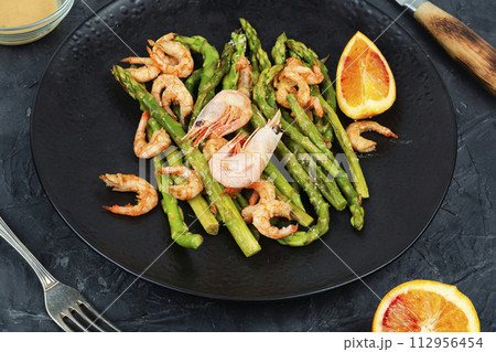 Appetizer with baked shrimp and asparagus. 112956454