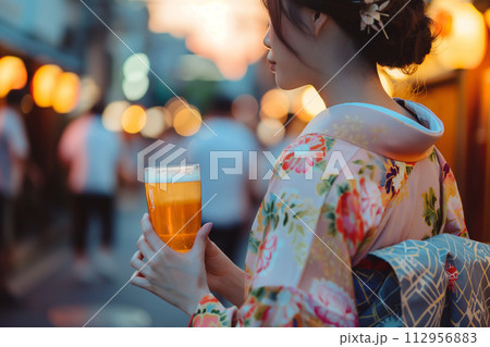 夜の街でビールを飲む着物姿の若い女性 112956883