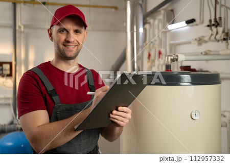 Skilled Technician Conducting Maintenance Check on Boiler in Industrial Facility 112957332