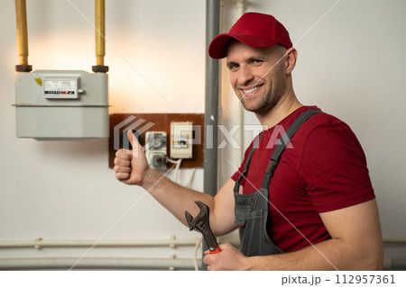 Skilled Technician Performs Gas Meter Maintenance in a Residential Building 112957361