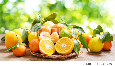fresh citrus fruits with leaves on a wooden table fresh citrus fruits with leaves on a wooden table 112957989