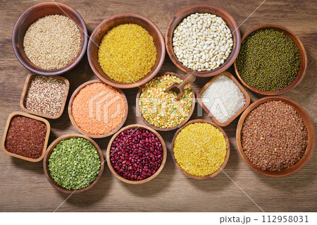 bowls of legumes, lentils, chickpeas, rice and beans on wooden background 112958031