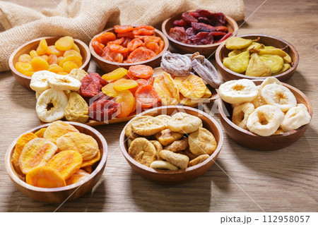bowls of various dried fruits on wooden background 112958057