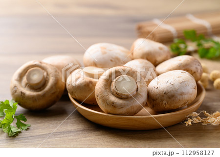 Fresh Champignon mushroom in bowl on wooden background Fresh Champignon mushroom in bowl on wooden background 112958127
