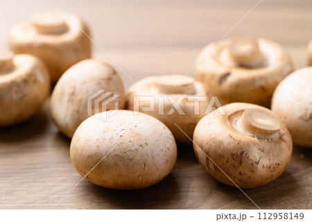 Fresh Champignon mushroom on wooden background 112958149