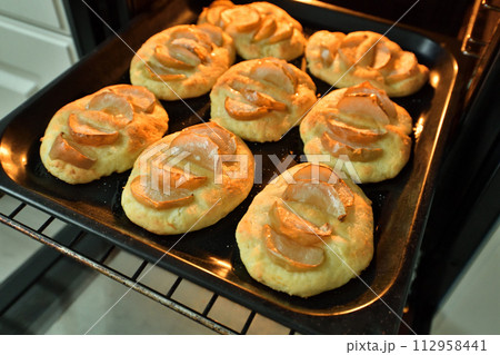 curd cheesecakes with an apples on a baking sheet curd cheesecakes with an apples on a baking sheet 112958441