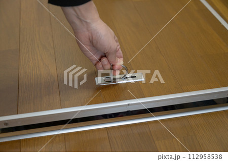床下収納を開け閉めする女性の手元 112958538