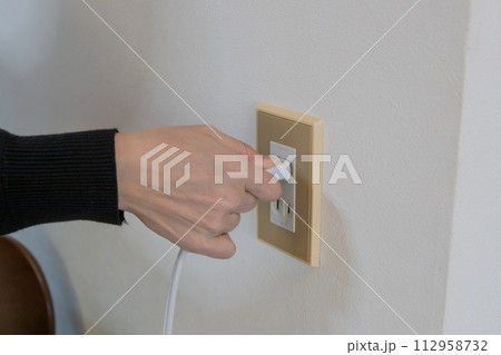 コンセントにプラグを差し込む手元 112958732
