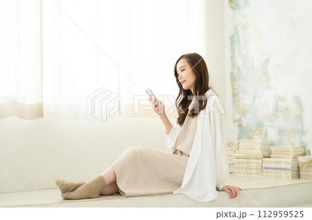 座ってスマホを見る女性 座ってスマホを見る女性 112959525