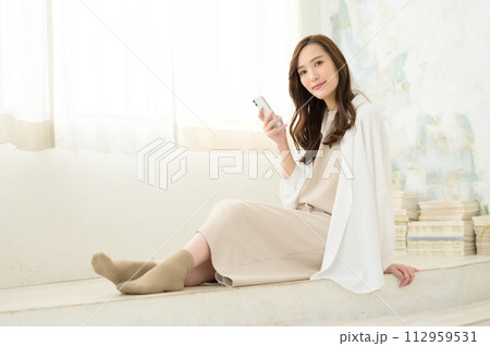 座ってスマホを見る女性 座ってスマホを見る女性 112959531