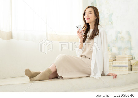座ってスマホを見る女性 座ってスマホを見る女性 112959540