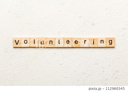 volunteering word written on wood block. volunteering text on table, concept 112960345
