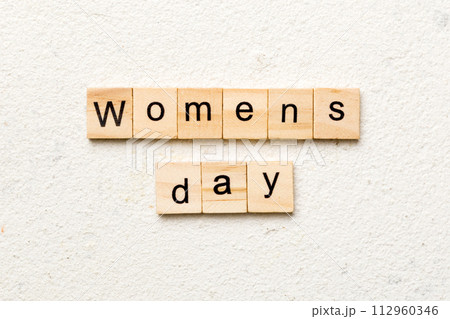Womans day word written on wood block. Womans day text on cement table for your desing, concept 112960346