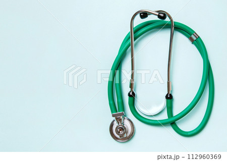 Top view of green medical stethoscope on colorful background with copy space. Medicine equipment concept 112960369