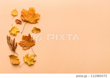 Autumn composition. Pattern made of dried leaves and other design accessories on table. Flat lay, top view 112960372