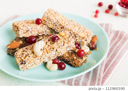 Various granola bars on table background. Cereal granola bars. Superfood breakfast bars with oats, nuts and berries, close up. Superfood concept Various granola bars on table background. Cereal granola bars. Superfood breakfast bars with oats, nuts and berries, close up. Superfood concept 112960390