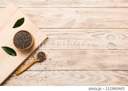 Chia seeds in bowl and spoon on colored background. Healthy Salvia hispanica in small bowl. Healthy superfood Chia seeds in bowl and spoon on colored background. Healthy Salvia hispanica in small bowl. Healthy superfood 112960465