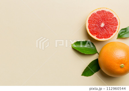fresh Fruit grapefruit with Juicy grapefruit slices on colored background. Top view. Copy Space. creative summer concept. Half of citrus in minimal flat lay with copy space 112960544