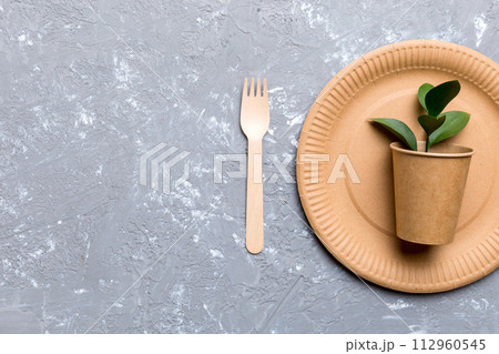 set of empty reusable disposable eco-friendly plates, cups, utensils on light white colored table background. top view. Biodegradable craft dishes. Recycling concept. Close-up set of empty reusable disposable eco-friendly plates, cups, utensils on light white colored table background. top view. Biodegradable craft dishes. Recycling concept. Close-up 112960545