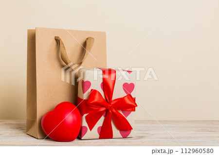 Shopping bag with gift box on colored background perspecrive view. Space for text holiday concept 112960580