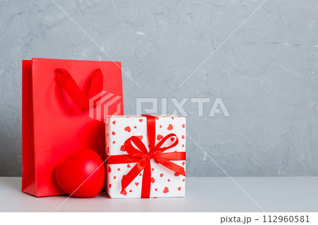 Shopping bag with gift box on colored background perspecrive view. Space for text holiday concept 112960581
