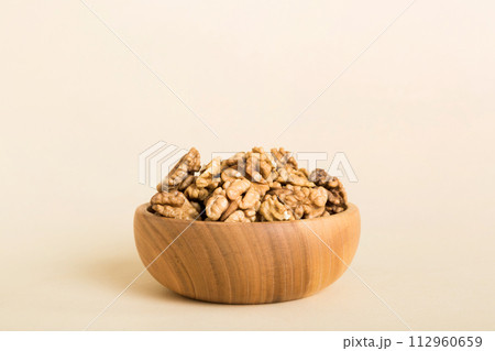 Fresh healthy walnuts in bowl on colored table background. Top view Healthy eating bertholletia concept. Super foods Fresh healthy walnuts in bowl on colored table background. Top view Healthy eating bertholletia concept. Super foods 112960659