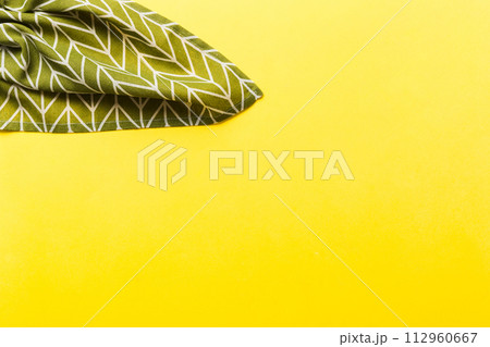 top view with green kitchen napkin isolated on table background. Folded cloth for mockup with copy space, Flat lay. Minimal style 112960667
