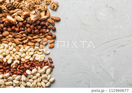 different nuts frame background. Close up, top view, flat lay with vopy space. Walnut, pistachios, almonds, hazelnuts and cashews different nuts frame background. Close up, top view, flat lay with vopy space. Walnut, pistachios, almonds, hazelnuts and cashews 112960677