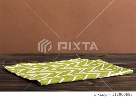 top view with green kitchen napkin isolated on table background. Folded cloth for mockup with copy space, Flat lay. Minimal style 112960685