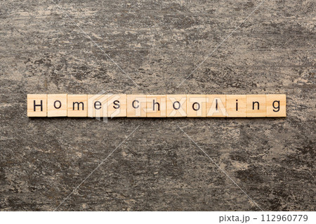 Home schooling word written on wood block. Homeschooling text on table, concept 112960779