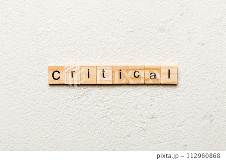 critical word written on wood block. critical text on table, concept critical word written on wood block. critical text on table, concept 112960868