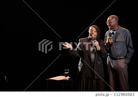 Portrait of two African American performers on dark stage with spotlight, copy space Portrait of two African American performers on dark stage with spotlight, copy space 112960883