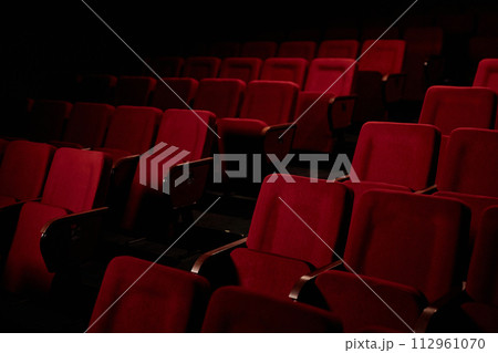 Graphic background image of empty seat rows in audience at theater with low light copy space 112961070