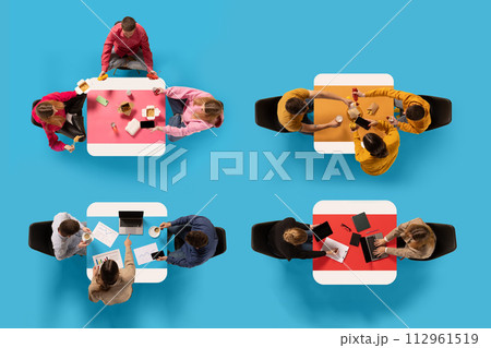 Top view of four groups of people engaged in various activities around different colored tables against blue background. 112961519