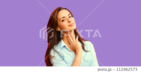 Portrait beautiful young brunette woman model posing on purple studio background 112962573