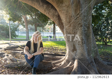 Young Woman with braces Smiling Under Tree in Park Young Woman with braces Smiling Under Tree in Park 112962613