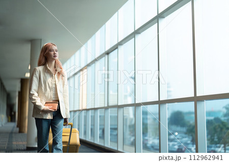 Airport travel and woman with passport, flight ticket or information of immigration, journey and luggage. identity document and international registration Airport travel and woman with passport, flight ticket or information of immigration, journey and luggage. identity document and international registration 112962941