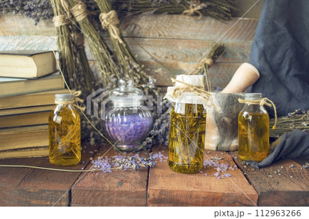 Vintage books, dried lavender flowers and bottles of essential oil on wooden background. 112963266