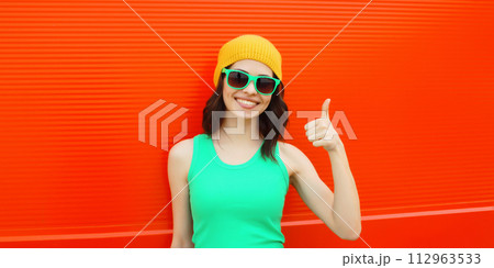 Summer portrait of happy smiling brunette young woman posing in yellow hat, green sunglasses Summer portrait of happy smiling brunette young woman posing in yellow hat, green sunglasses 112963533