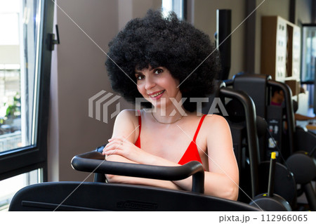 Woman athlete with curly hair extensions, interesting creative hairstyle 112966065