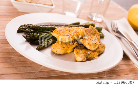 Fried chicken breast pieces with asparagus on white plate Fried chicken breast pieces with asparagus on white plate 112966307