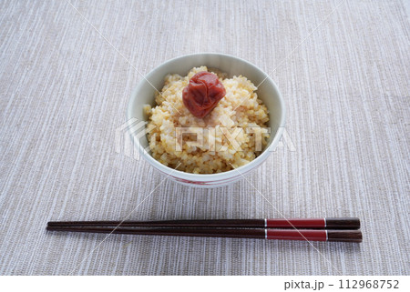 梅干しが乗った炊き立ての熱々の玄米ごはんと粗食の和食の朝食 梅干しが乗った炊き立ての熱々の玄米ごはんと粗食の和食の朝食 112968752