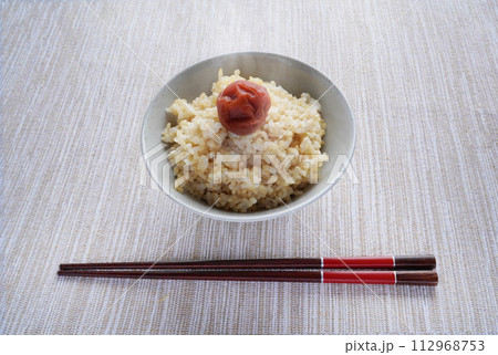 梅干しが乗った炊き立ての熱々の玄米ごはんと粗食の和食の朝食 梅干しが乗った炊き立ての熱々の玄米ごはんと粗食の和食の朝食 112968753