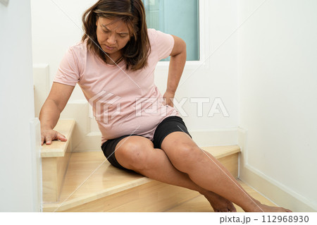 Asian lady fall down the stairs and pain at hip and waist because slippery surfaces. 112968930