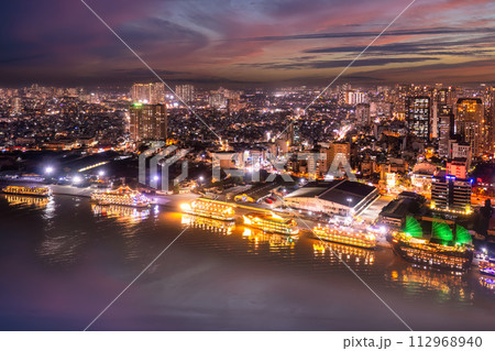 Aerial panoramic cityscape view of HoChiMinh city and the River Saigon, Vietnam with blue sky at sunset. View from Thu Thiem peninsula 112968940