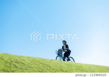 自転車に乗って通勤するミドル女性 112969320