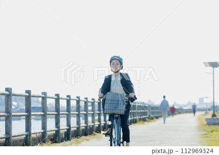 自転車に乗って通勤するミドル女性 112969324