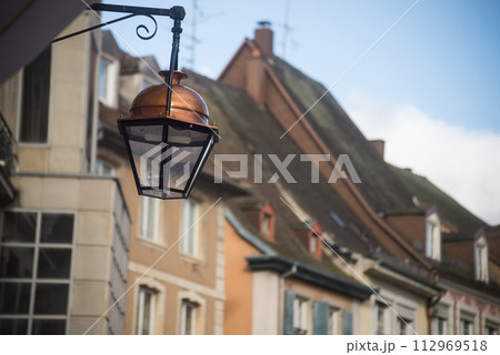 closeup of vintage street light on historic building facade background in Mulhouse - France 112969518