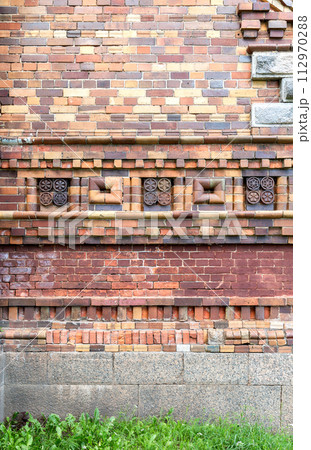 Old red brickwork with decorative pattern of the Cathedral of the Nativity of the Blessed Virgin (1900) in Lyubytino, Russia 112970288