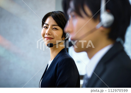 オフィスでヘッドセットをつけて対応するオペレーターの女性 112970599